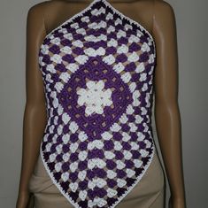 a mannequin wearing a purple and white crocheted top