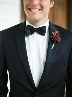 a man in a tuxedo smiles at the camera