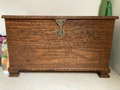 an old wooden chest with carvings on the front and sides, sitting in a corner