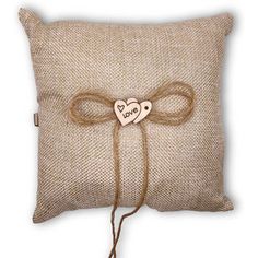 a pillow with a bow on it and a wooden heart attached to the back of it