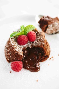 chocolate cake with raspberries on top and powdered sugar