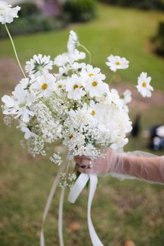 a person holding a bouquet of white flowers