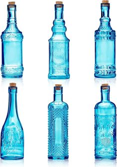 four blue glass bottles with corks on the top one is empty and two are empty