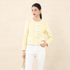 Crafted with a premium light yellow textured fabric reminiscent of the iconic Coco Chanel style, this jacket exudes sophistication and elegance. The subtle shimmer adds a touch of luxury, making it a valuable addition to your wardrobe.Featuring a short boxy silhouette, the jacket offers versatility and comfort. The classic round neckline complements all body types, ensuring a flattering fit without constraints.Adding to its charm, the jacket is designed with a hint of relaxed volume in the silhouette, creating a perfect balance. The contrast trim in beige and delicate bow detail on the shoulders enhance the romantic vibe, while the light-colored interior lining adds a refreshing and vibrant touch. Chic Formal Tweed Jacket, Elegant Beige Tweed Jacket For Office, Elegant Beige Tweed Office Jacket, Elegant Yellow Office Blazer, Chic Cream Tweed Jacket For Spring, Elegant Spring Office Tweed Jacket, Elegant Spring Evening Tweed Jacket, Elegant Yellow Winter Blazer, Chic Beige Tweed Jacket