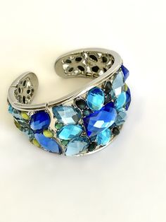 "Dressed Up or Down, This Cuff will Take You There in Shimmering Style Faceted Stones In Shades of Blue Envelops The Wrist In Glorious Sparkling Color Contour Designed to Fit The Wrist with a Genius Flexible Construction That Allows For Easy On- Off Super Cool Paired With Jeans and a Tee Shirt, Pretty With Summer Dresses, Stylish In The Evening, Sophisticated and Chic Over the Sleeve of a Black Sweater in the Cooler Months Would Pair Beautifully with many items in my shop, Including the Items Pr Turquoise Bangle Bracelets For Party, Blue Metal Jewelry With Bracelet Strap, Blue Metal Bracelet Jewelry, Blue Jewelry With Bracelet Strap, Blue Bracelet Jewelry, Adjustable Blue Party Bracelets, Elegant Blue Metal Beaded Bracelets, Blue Beaded Bangle Bracelets, Turquoise Bangle Bracelet For Party