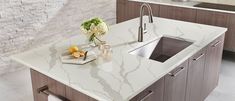 a modern kitchen with marble counter tops and stainless steel sink faucet in the center