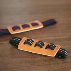 two orange and black objects sitting on top of a wooden table next to each other