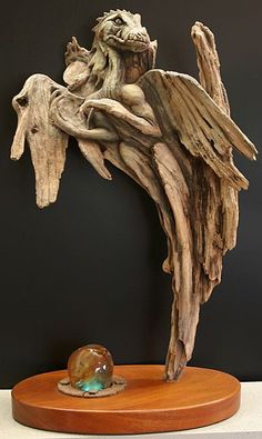 a sculpture of an angel with wings on a wooden stand