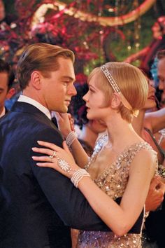 a man in a tuxedo and a woman in a sequin dress dance together