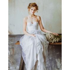 a woman in a white dress sitting on a bench