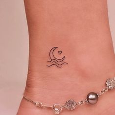 a woman's foot with a small tattoo on the side of her leg and an ankle chain