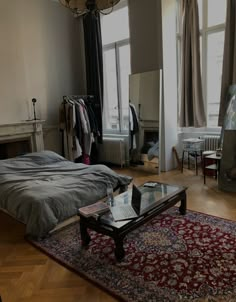 a bed room with a neatly made bed and a rug on the floor next to it