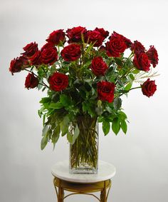 a vase filled with red roses on top of a table