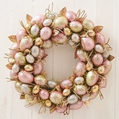 a pink and gold easter egg wreath on a white wall