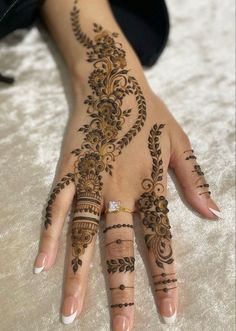 a woman's hand with henna tattoos on it