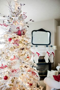 a white christmas tree decorated with red and silver ornaments