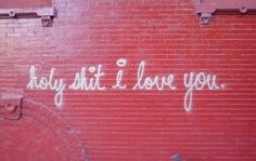 graffiti on the side of a red brick building with words written in white spray paint