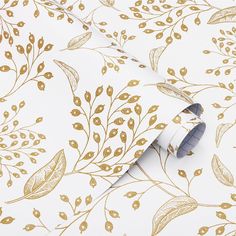 a white and gold wallpaper with golden leaves on it, next to a roll of tape