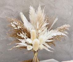 a vase filled with lots of white and brown flowers