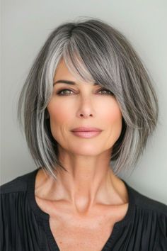 A smoky salt and pepper bob combines the edge of sharp angles with the softness of feathered layers. The color seamlessly transitions back and forth from black to gray, offering a modern twist on the classic bob. Click here to see more stunning bob hairstyles for women over 60. Medium Salt And Pepper Hairstyles, Shoulder Length Salt And Pepper Hair Over 50, Trendy Gray Hairstyles, Grey Layered Bob Hairstyles, Bobs For Grey Hair Over 50, Short Grey Hair Women, Asian Salt And Pepper Hair, Grey Hair Bob With Bangs, Short To Medium Bob Hairstyles