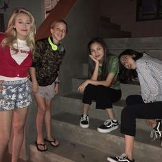 four young people are posing on the steps