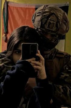 a woman taking a selfie in front of a soldier