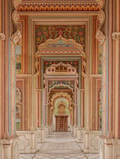 an intricately decorated hallway with columns and paintings on the walls, along with marble flooring