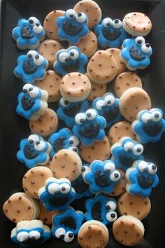 cookies with blue and brown icing are arranged on a black plate