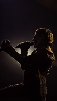 a woman in costume holding a microphone to her mouth