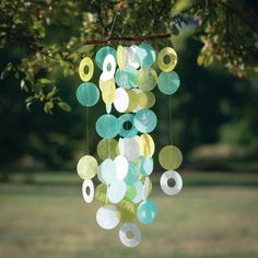 a wind chime hanging from a tree in a park with lots of circles on it