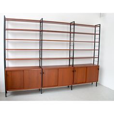 two shelving units with wooden doors and metal legs