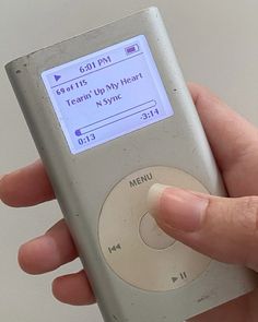 a hand holding an old style mp3 player