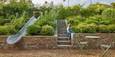 a woman standing at the bottom of stairs next to a slide