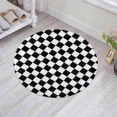 a black and white checkered pattern is on the floor next to a potted plant