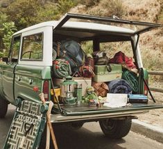 the back end of a pick up truck with luggage and camping gear in the bed