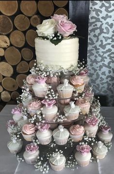 a wedding cake and cupcakes on a table