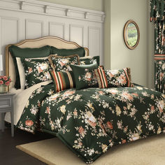 a bed in a room with green walls and floral bedspread, pillows and curtains