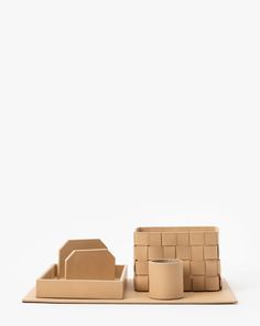 a set of cardboard boxes and cups sitting on top of a white surface with one box in the middle