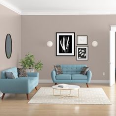 a living room with two blue couches and pictures on the wall