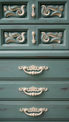 an old dresser painted in blue and white with ornate carvings on the front door handles