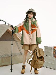 a woman standing in front of a tent with a backpack and camping gear on the ground