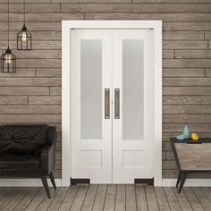 a black chair sitting in front of a white door on a wooden floor next to a wall