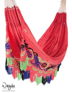 a red hammock with fringes hanging from it