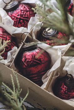 some red ornaments are in a box on the table