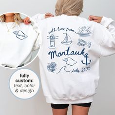 the back of a woman's sweatshirt with an image of boats and lighthouses on it