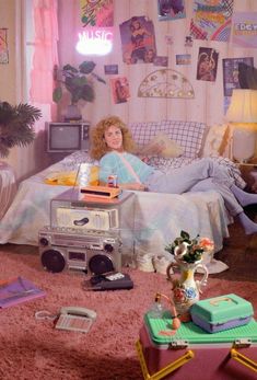 a woman sitting on top of a bed in a room filled with furniture and decor