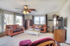 a living room filled with furniture and a flat screen tv on top of a wooden stand