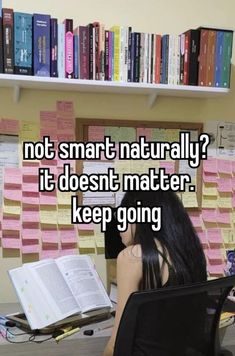 a woman sitting at a desk with a book in front of her