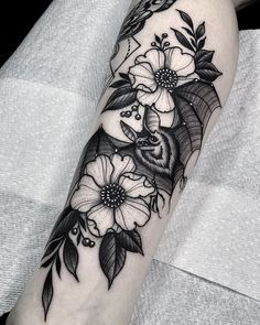 a bat and flowers tattoo on the arm