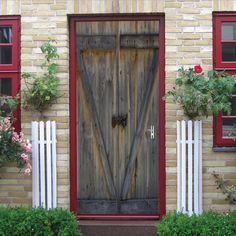 a house with red shutters and wooden doors